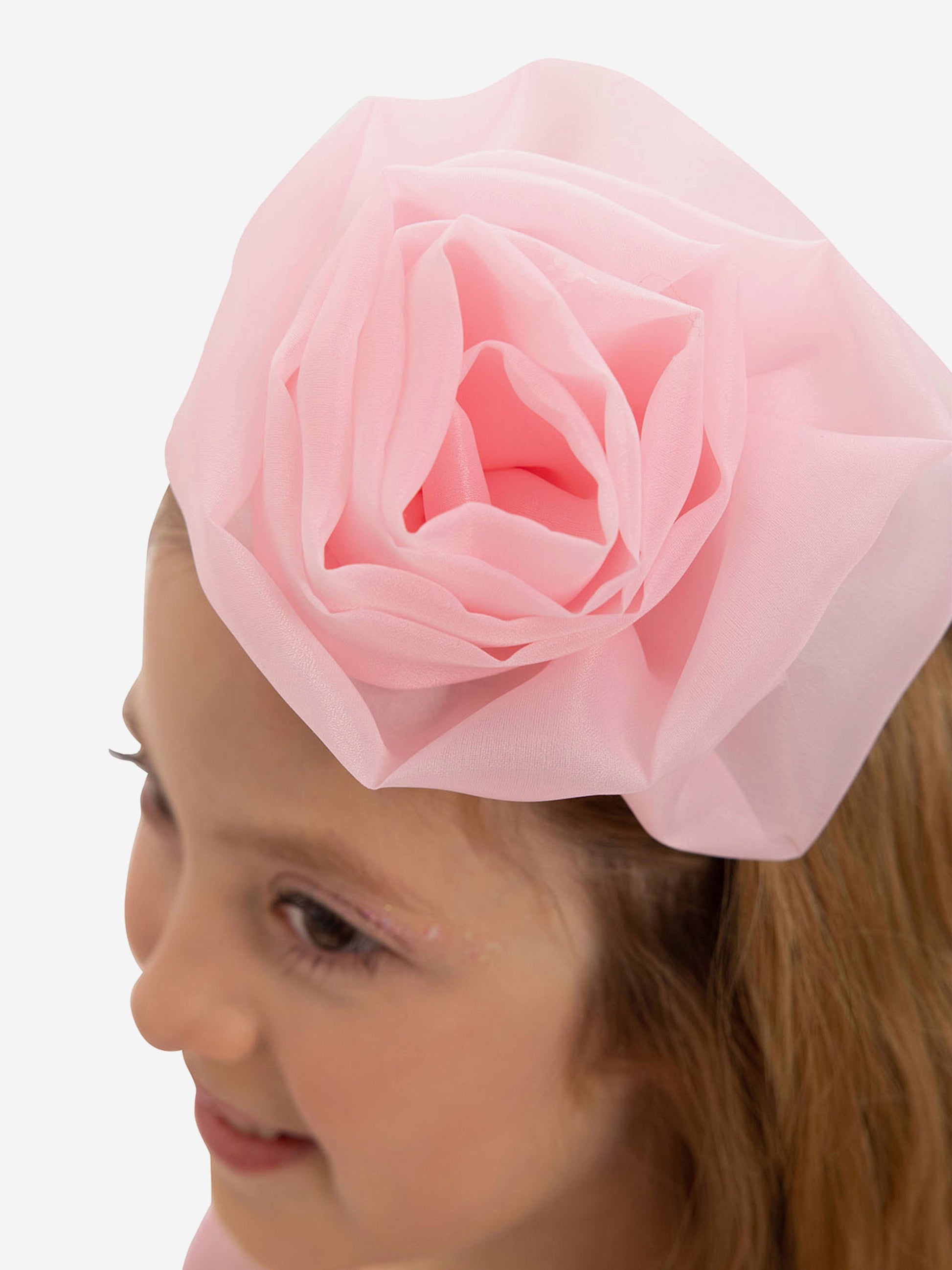 Pink fabric flower headband on a child