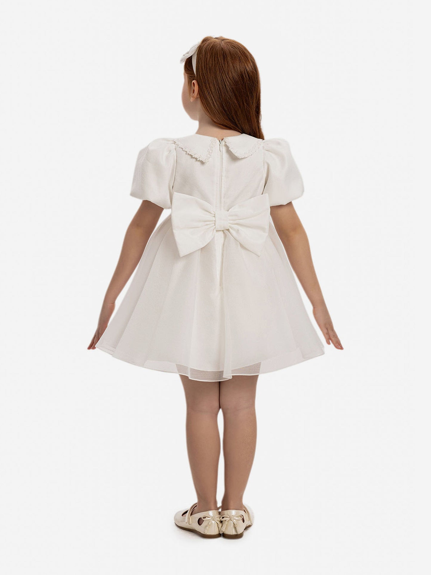White baby dress back view with gathered waist and large bow at back