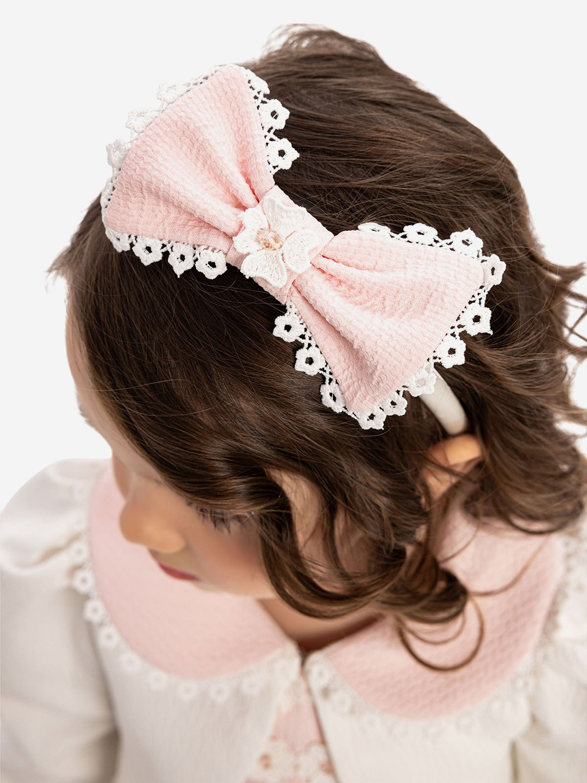 Pink bow headband with lace edging and small floral detail