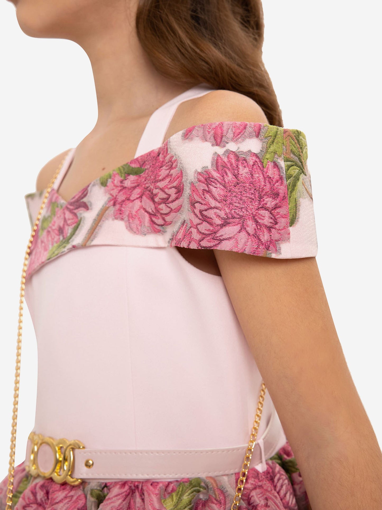 Rosa Kleid mit schulterfreiem Blumenmuster und goldener Kette zur Mini-Tasche