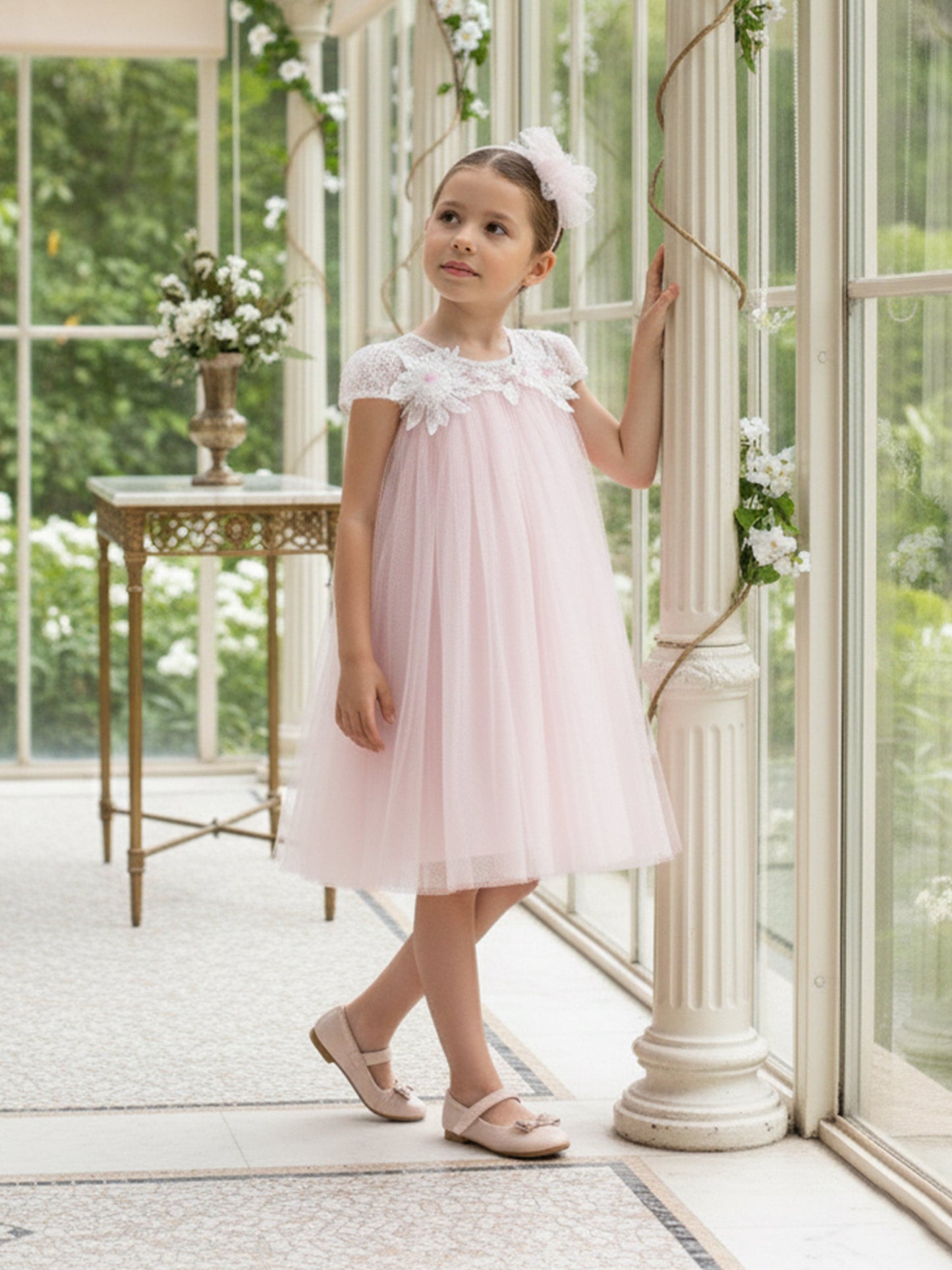 Pink tulle occasion dress with floral neckline and cap sleeves, wearing headband