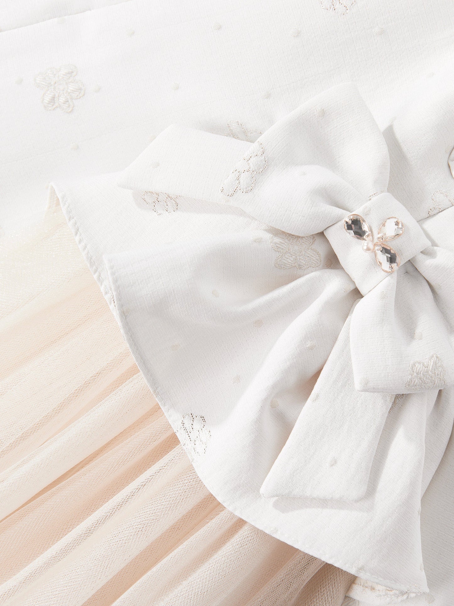 Ivory bow detail on dress bodice with subtle floral embroidery