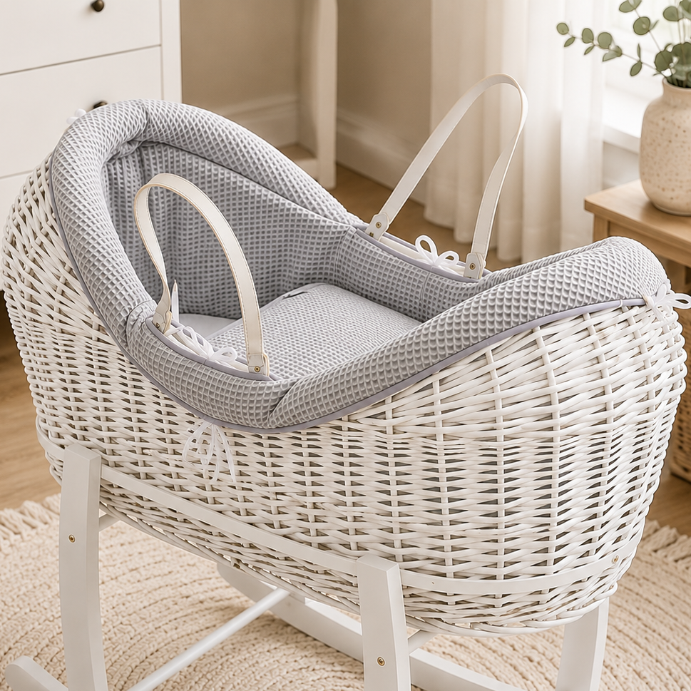 Grey wicker baby moses basket with textured waffle bedding and white carry handles