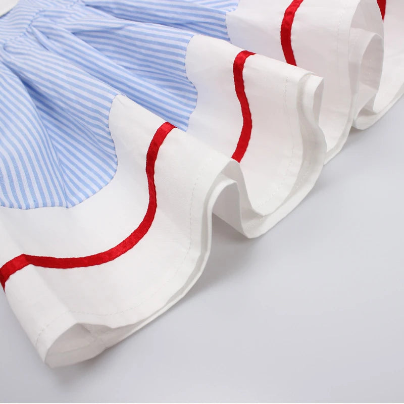 Girls blue striped summer dress close-up of white skirt with red trim