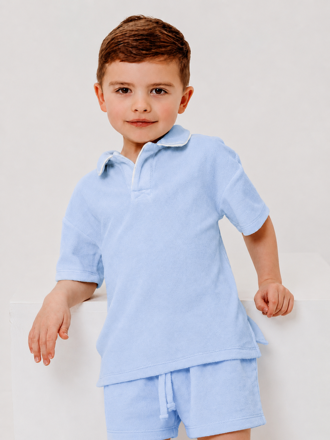 Blue towelling polo shirt with short sleeves and matching blue shorts