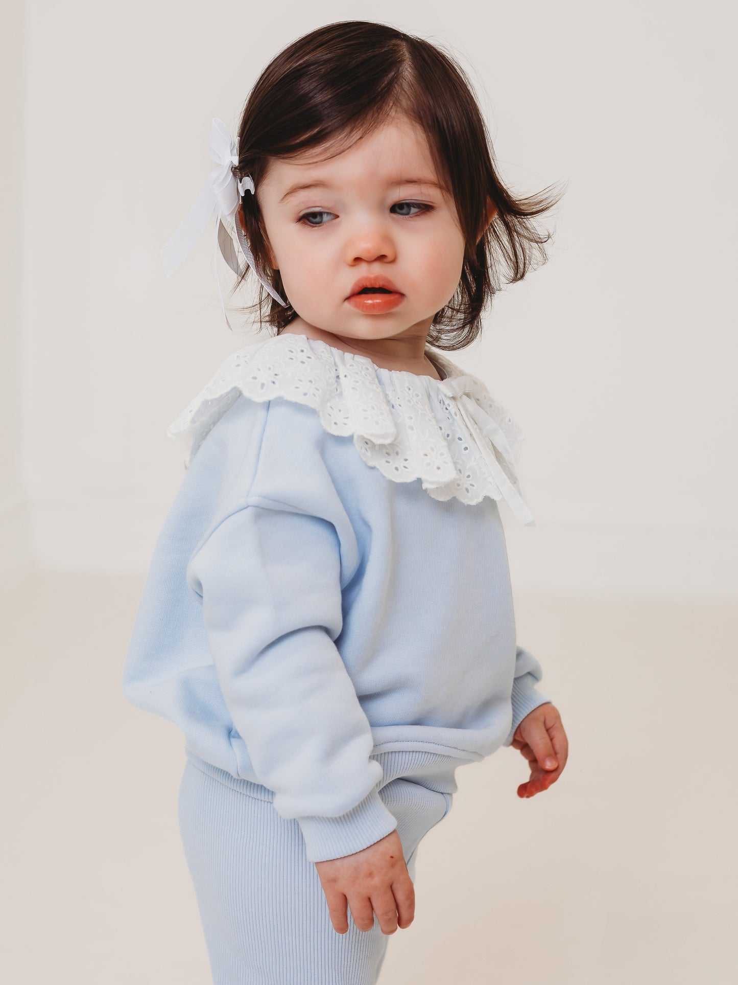 Light blue baby top and ribbed leggings set with white eyelet frill collar, side view