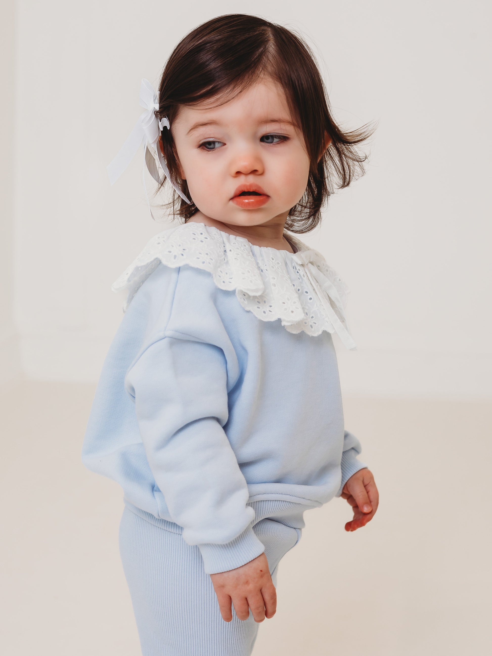 Light blue baby top and ribbed leggings set with white eyelet frill collar, side view