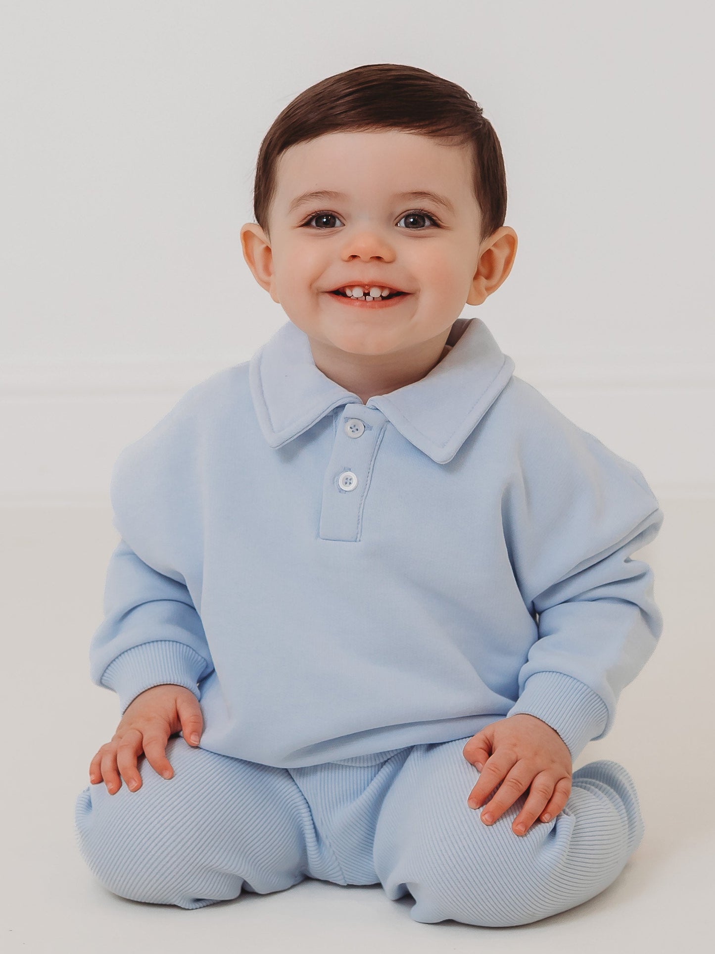 Light blue kids polo top with collar and button placket, paired with ribbed leggings