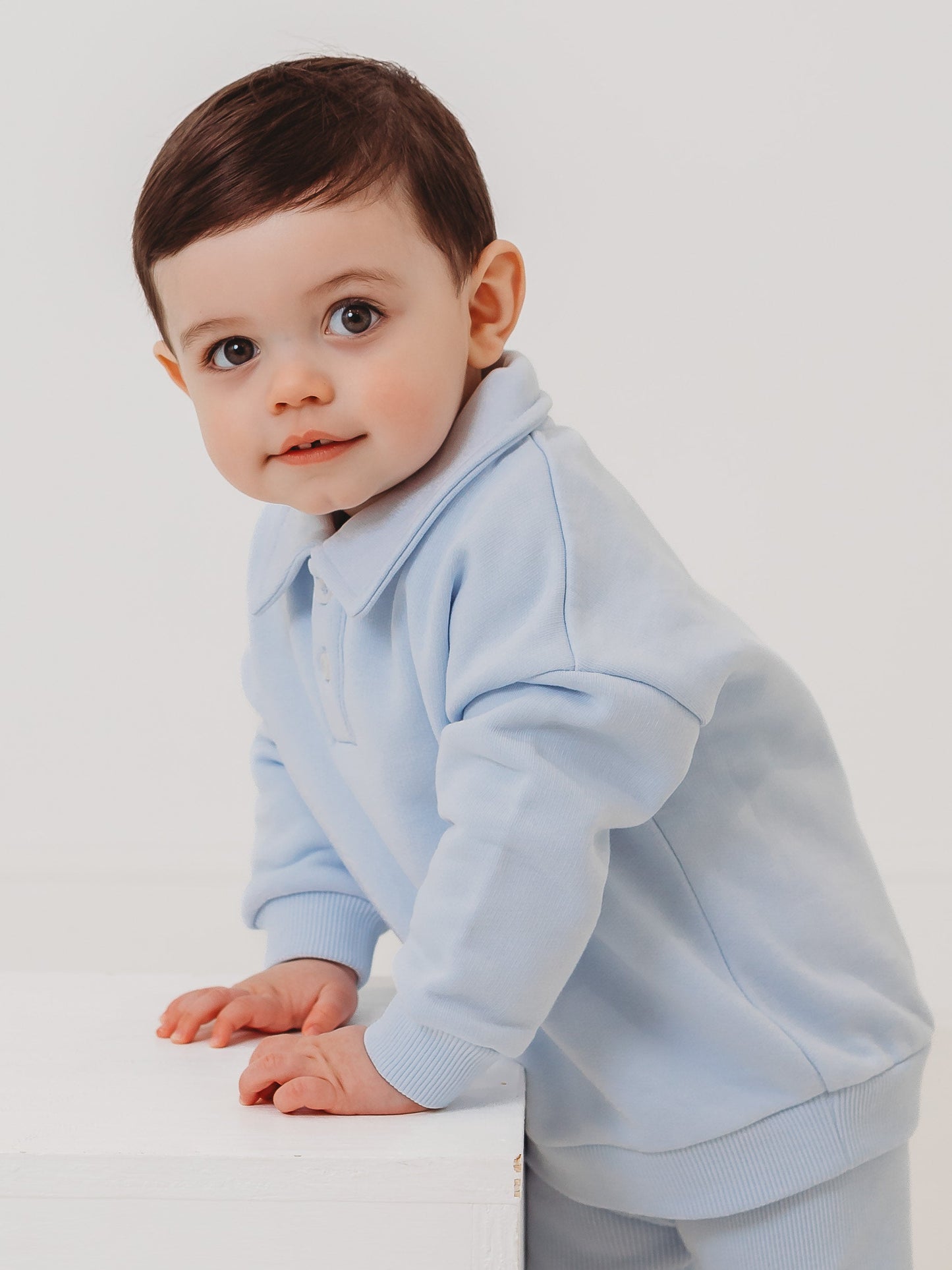 Light blue polo collar top and ribbed leggings set, close-up side crawl pose