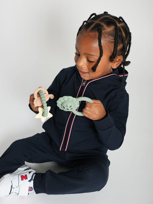 Lion rattle and teether held by a child, with ring and face details
