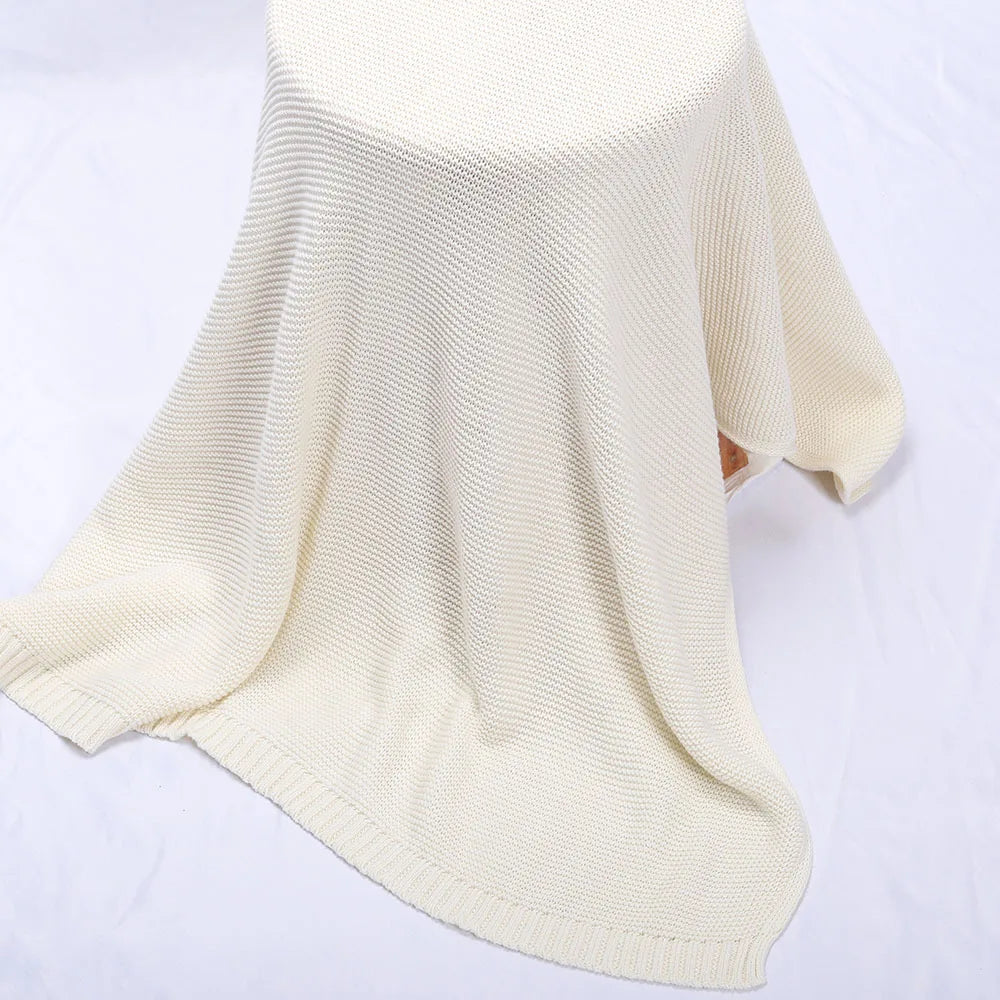 Cream knitted swaddle blanket with ribbed trim