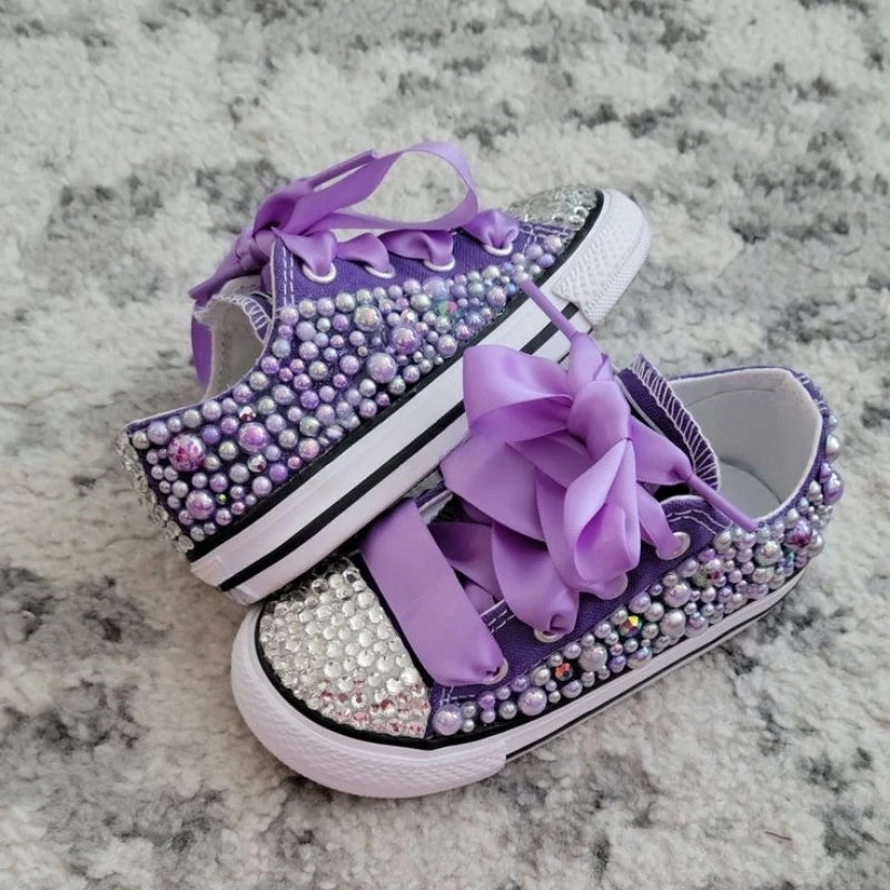 Purple canvas pumps with rhinestone-and-pearl trim, big bow, striped sole