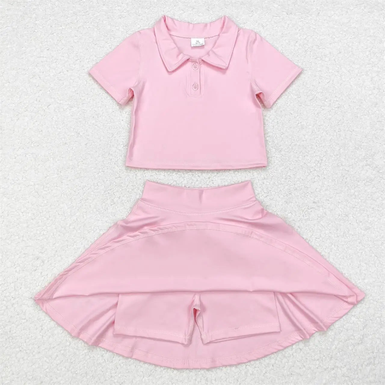 Pink outfit with a shirt and skirt on a light gray background
