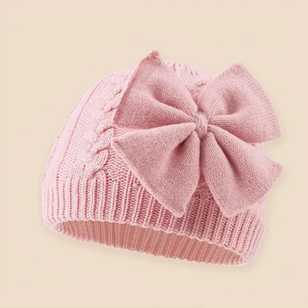 Light pink knitted baby beanie hat with large bowknot detail