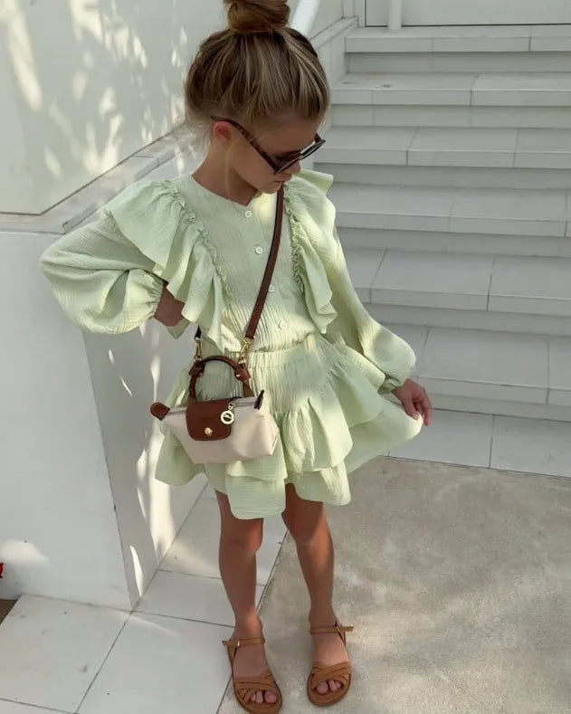 Mint green ruffle smock shirt and tiered skirt set, angled side view with ruffled shoulders
