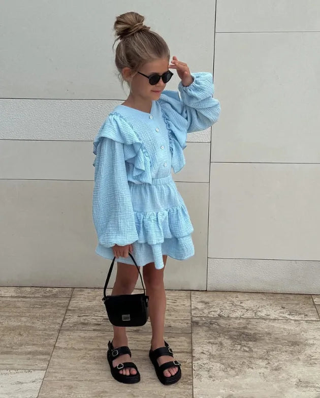 Powder blue ruffle smock shirt and tiered skirt set, side view with ruffle shoulders