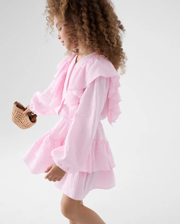 Girls pink ruffle smock shirt and tiered skirt set, side view with layered skirt