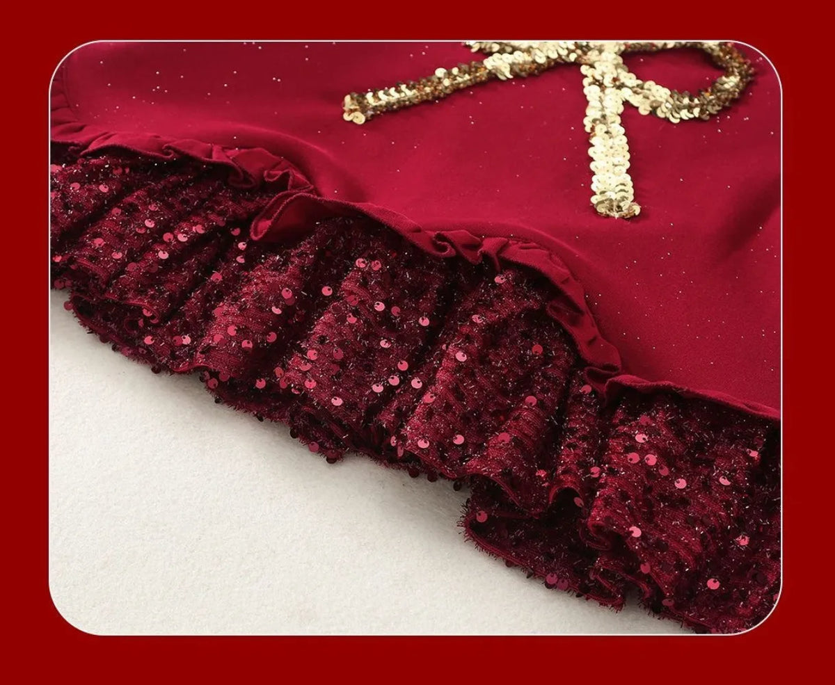 Close-up of glittery ruffle trim and layered skirt detail on red girls dress