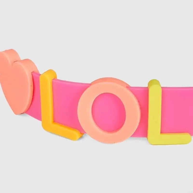 Pink goggles with orange decorative side and yellow frame accents; close-up