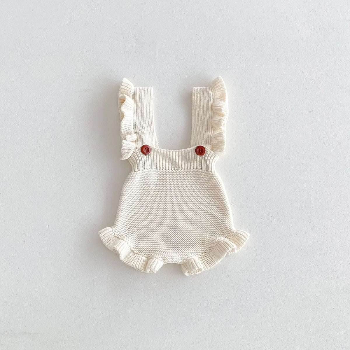 Beige knit sleeveless flounce romper with red button accents