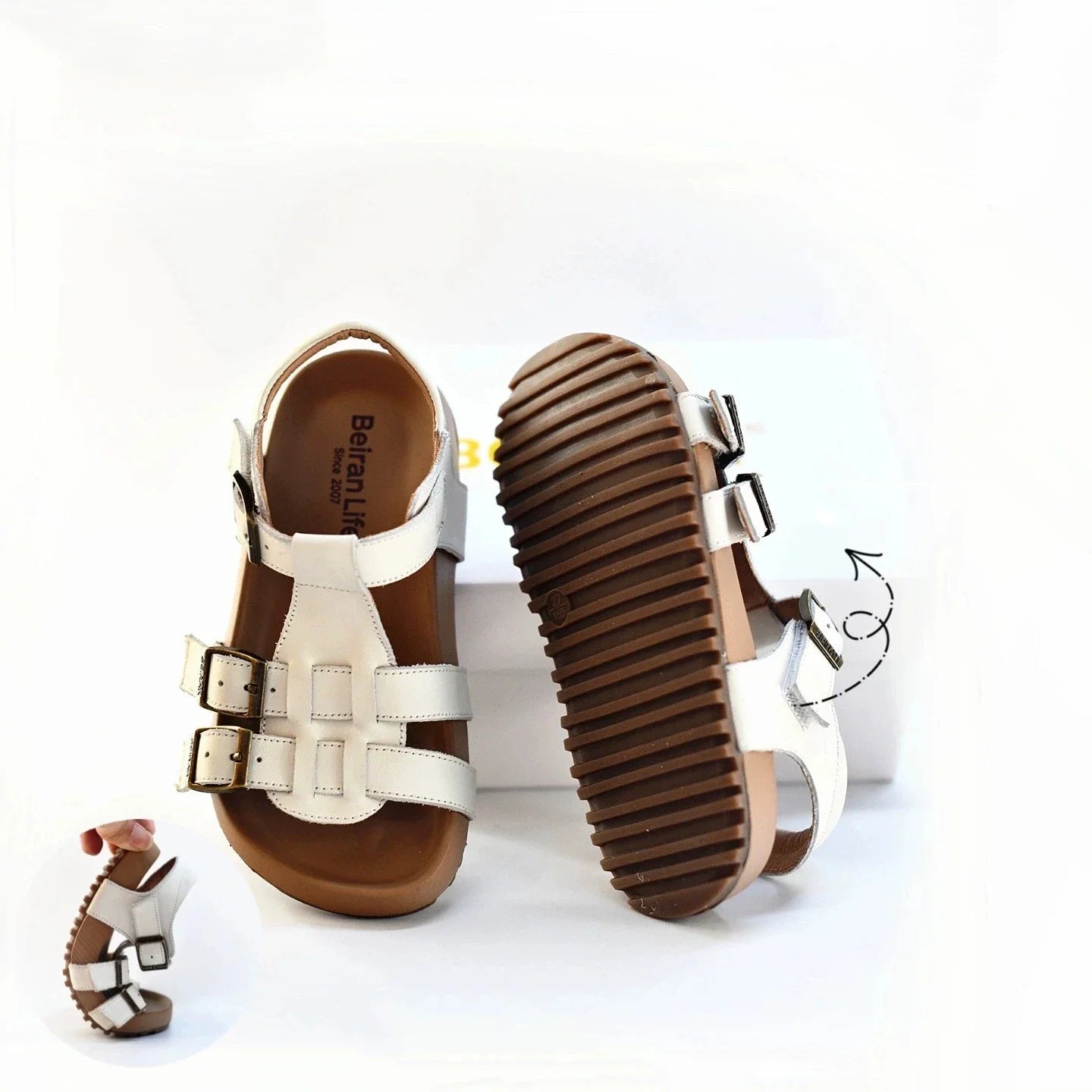 Kids white sandal showing outsole tread and side straps with buckle details