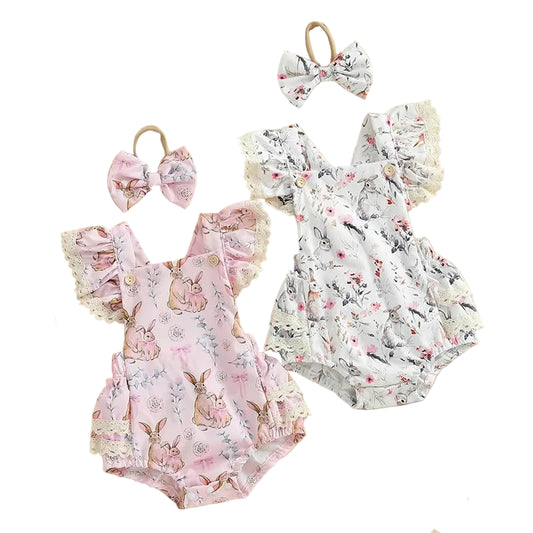 Two baby rompers with floral and bunny print, accompanied by hair bows and a plush toy on a beige background.