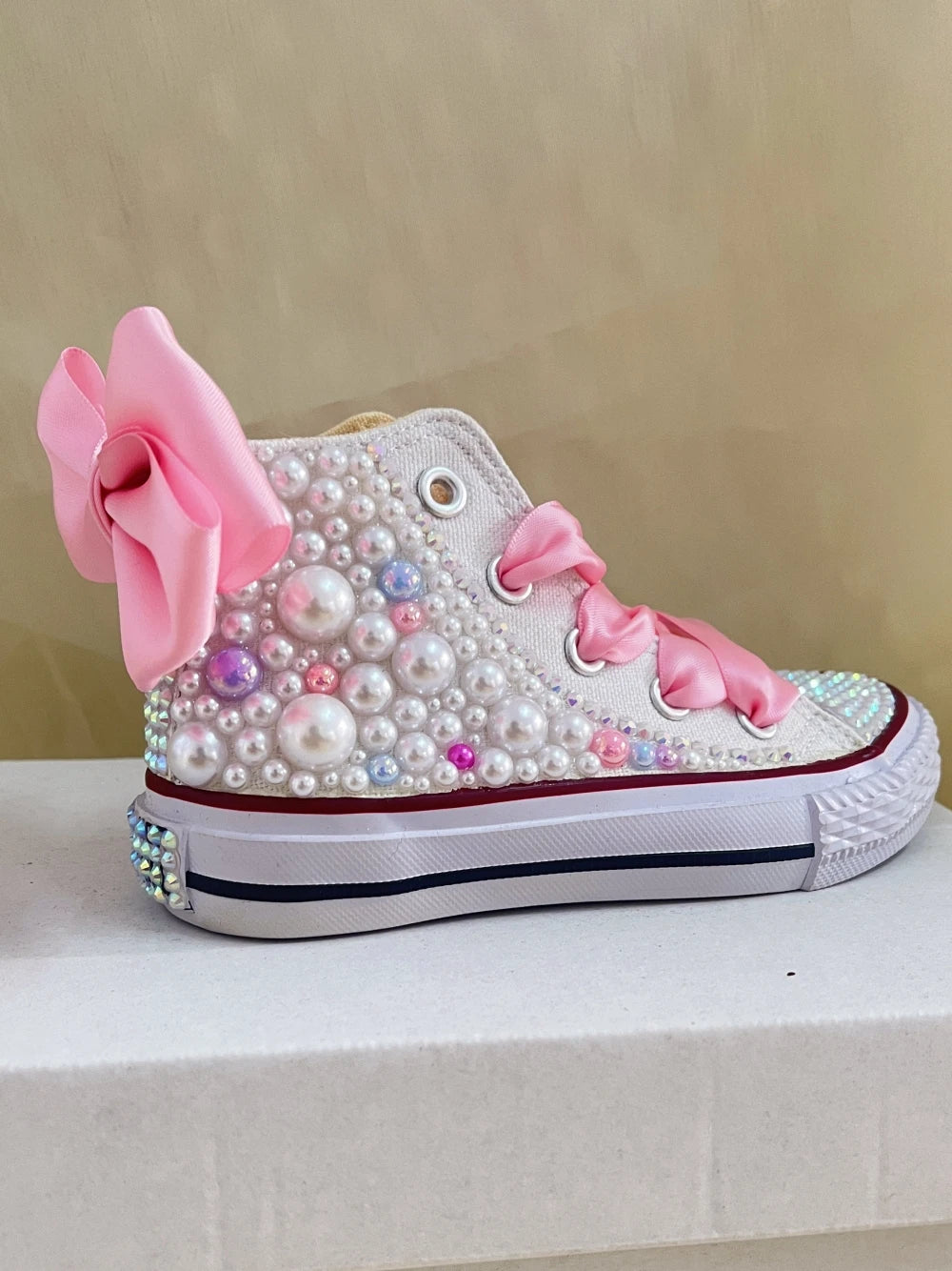 White canvas high-top boots with pearl embellishment and pink satin bows