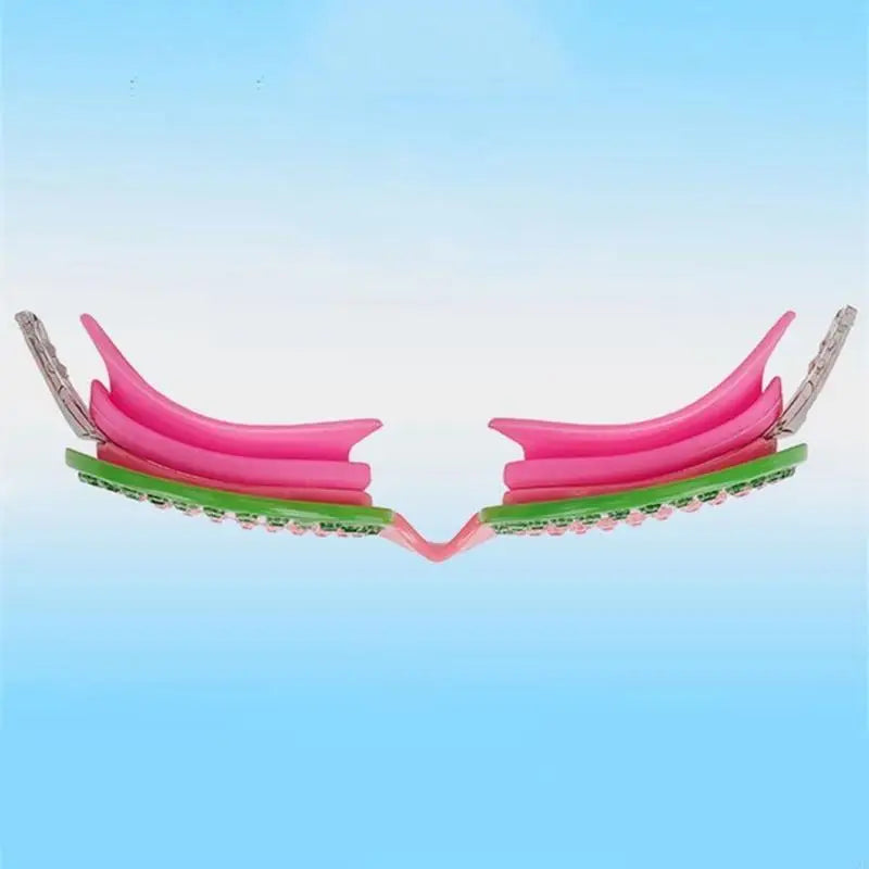 Pink swim goggles with layered lens look and green beaded border; front view