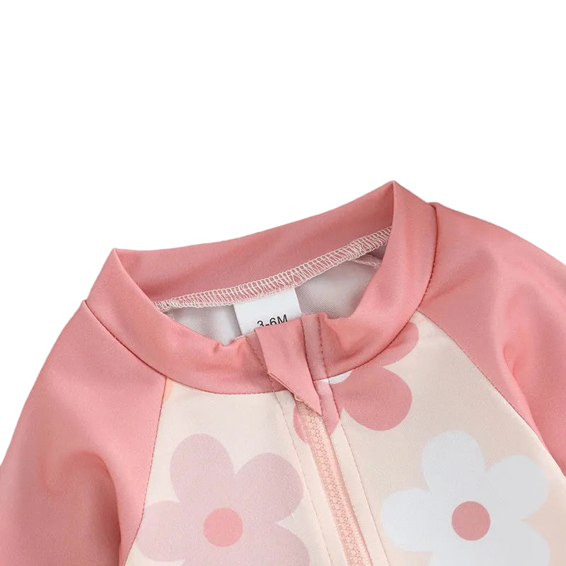 Pink and white children's swimsuit with floral patterns on a light blue background