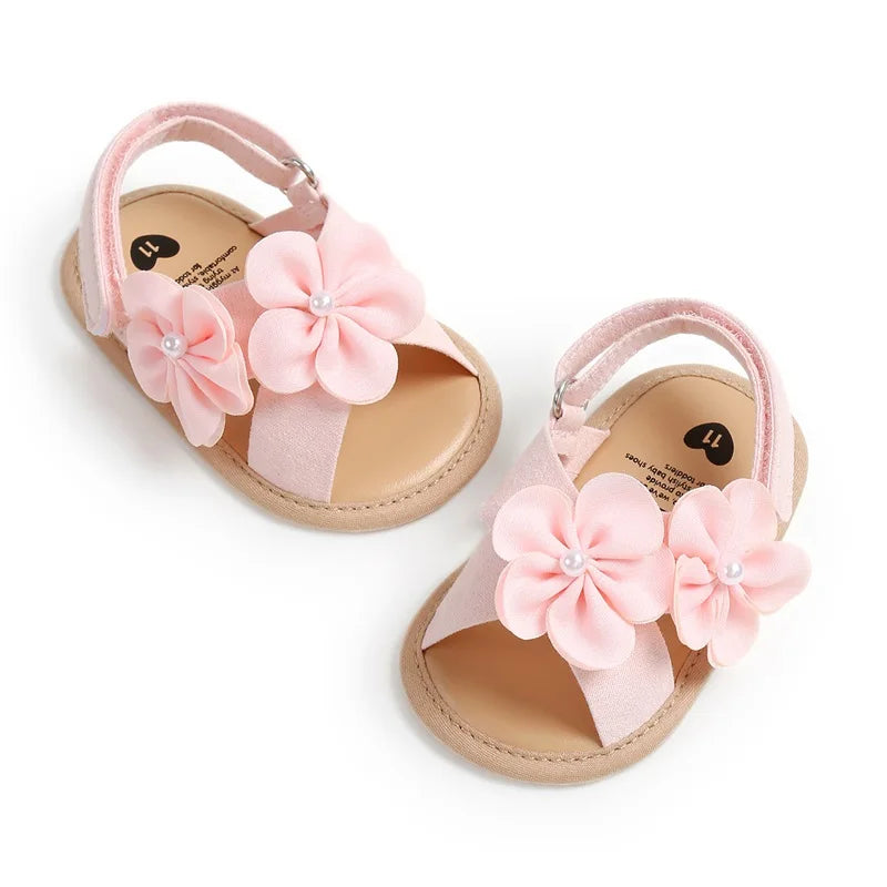 Pair of baby sandals with pink flowers on a white background
