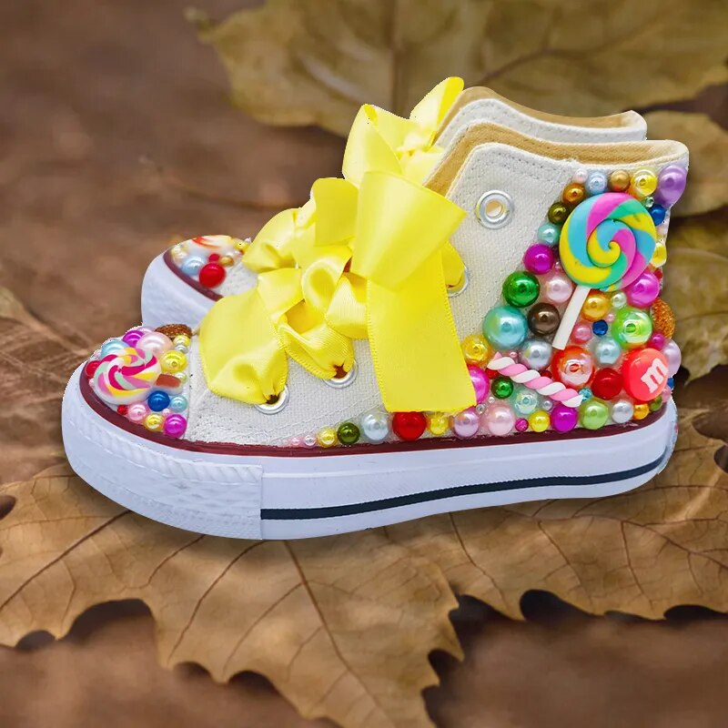 White canvas high-top baseball boots with yellow bow and colorful bead laces