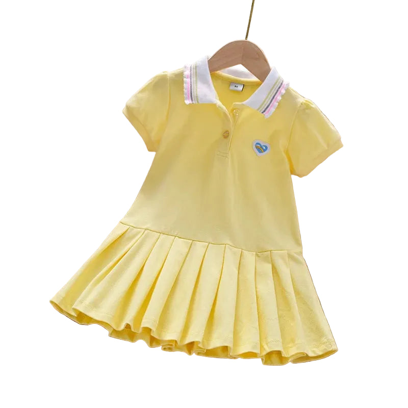 Yellow dress with a heart emblem on a wooden surface