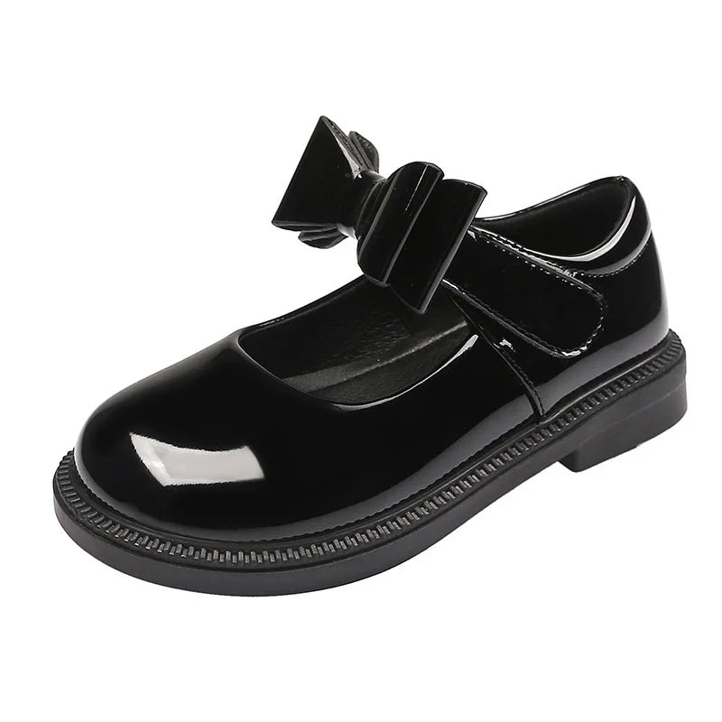 Black patent leather shoe with a bow on a white background