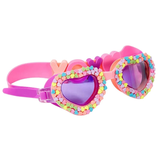 Pink swimming goggles with heart accents and “XOXO” lettering, anti-fog lenses, UV protection, and an adjustable strap for a secure and comfortable fit.

