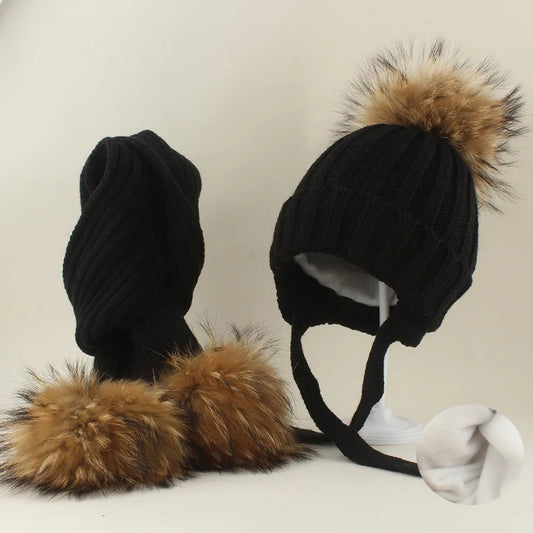 Black knit hat with tan fur pom-pom and matching scarf with fur-trim ends