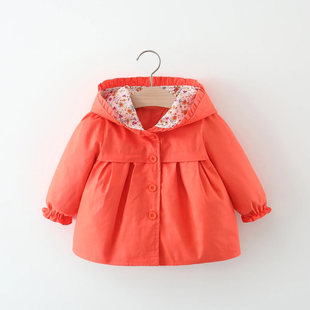 Baby hooded jacket in coral red with ruffled hood, floral lining, and button front.