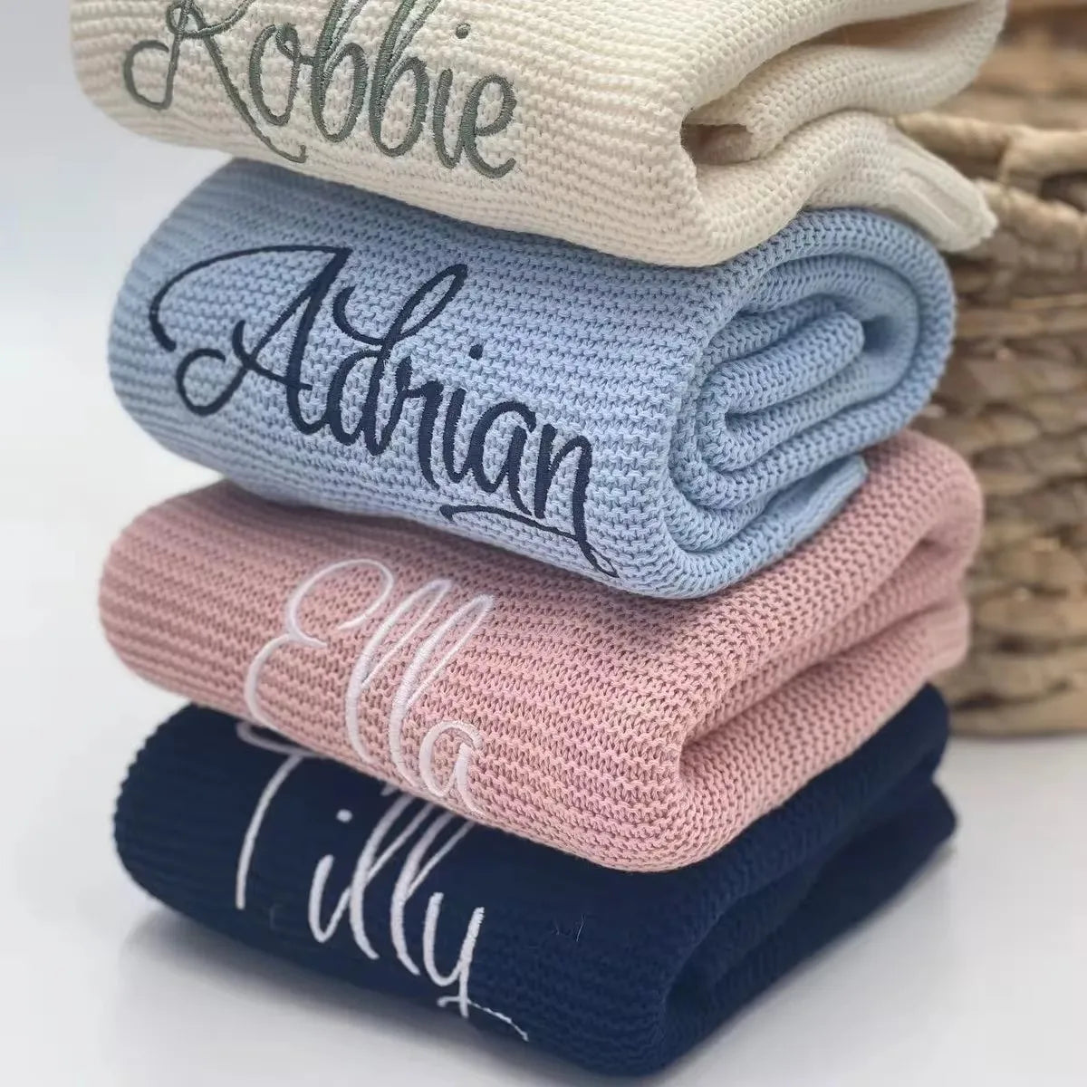 Personalized knit baby blanket set with embroidered names in navy, pink, and light blue