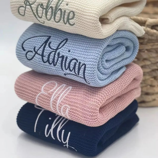 Personalized knit baby blanket set with embroidered names in navy, pink, and light blue