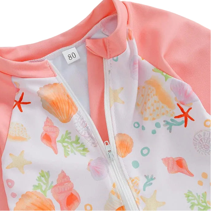 Children's pink jacket with a white zipper and sea-themed pattern on a light blue background