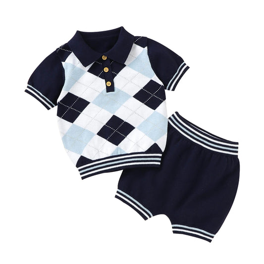 Baby outfit with checkered romper and navy shorts on a white background