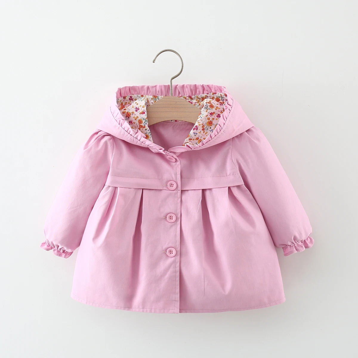 Baby light pink hooded jacket with ruffled hood, floral lining, and three buttons.