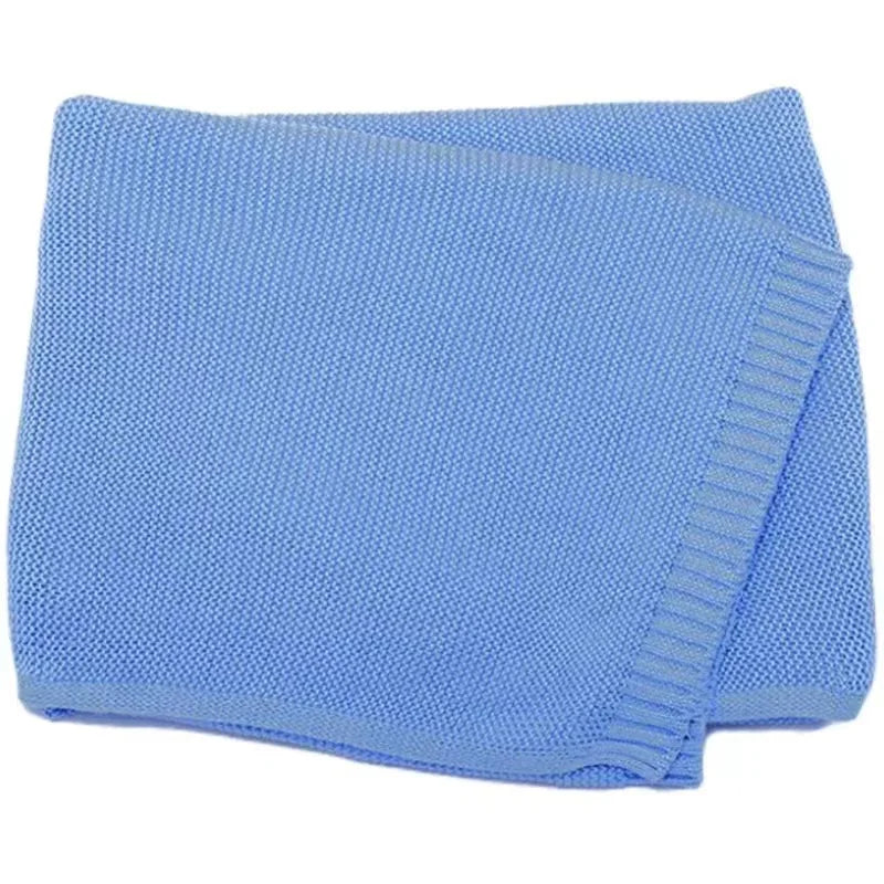 Light blue knitted baby blanket with stitched ribbed edge border