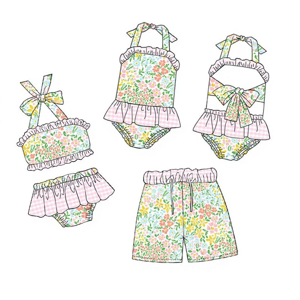 Girls floral swim set flat lay: ruffled bikini top, bow straps, and skirted bottoms