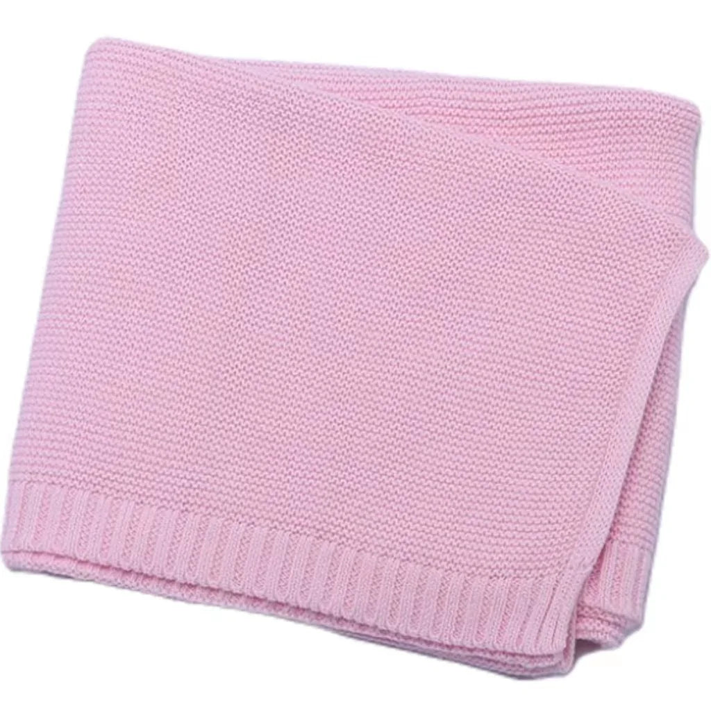 Pink knitted baby swaddle blanket folded with ribbed edge