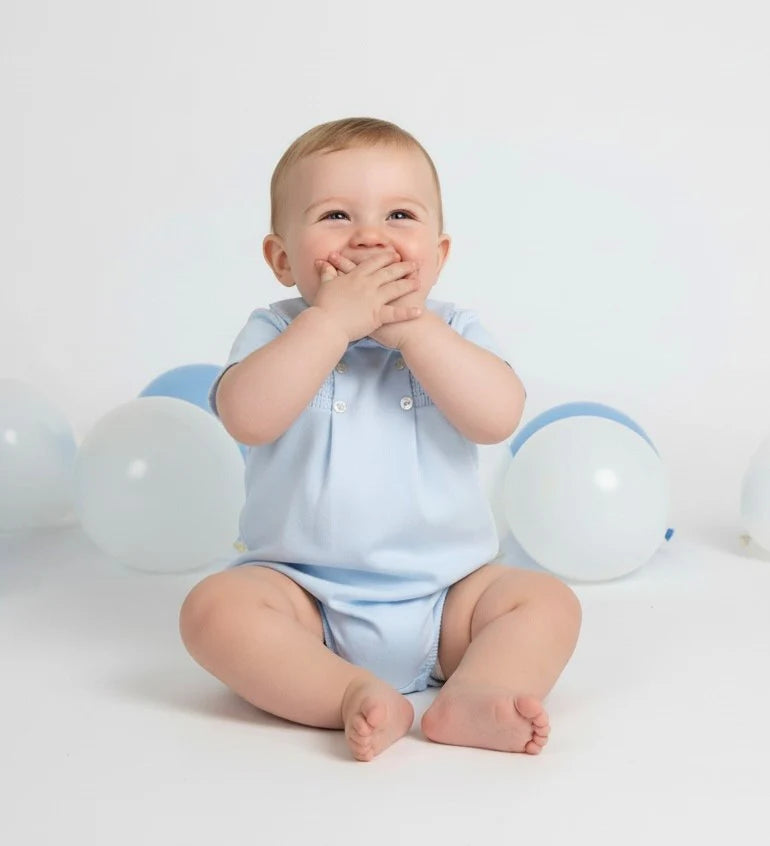 Pastel blue smocked cotton romper, short sleeves and button front
