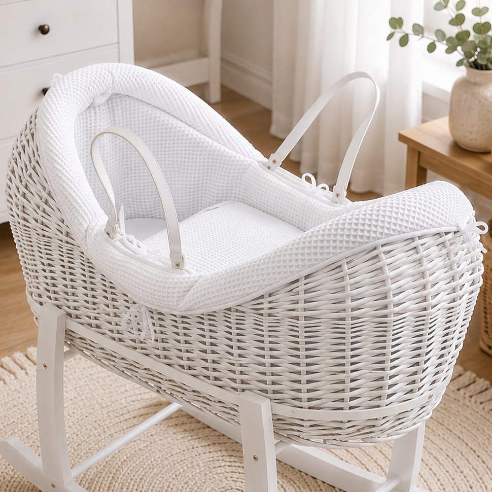 White wicker baby moses basket with textured waffle bedding and white carry handles