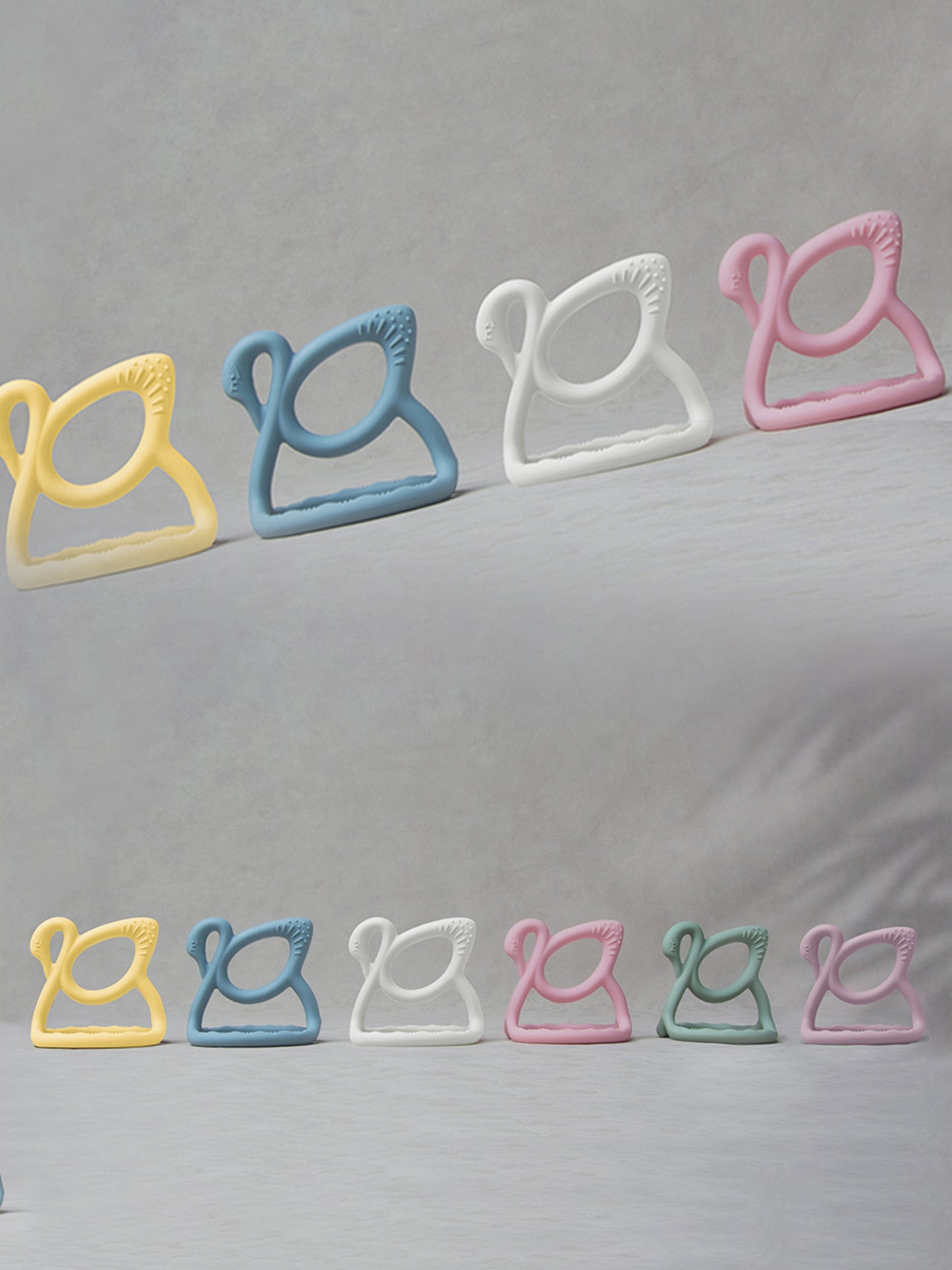 Blue swan teether among pastel colors, ridged gripping edge