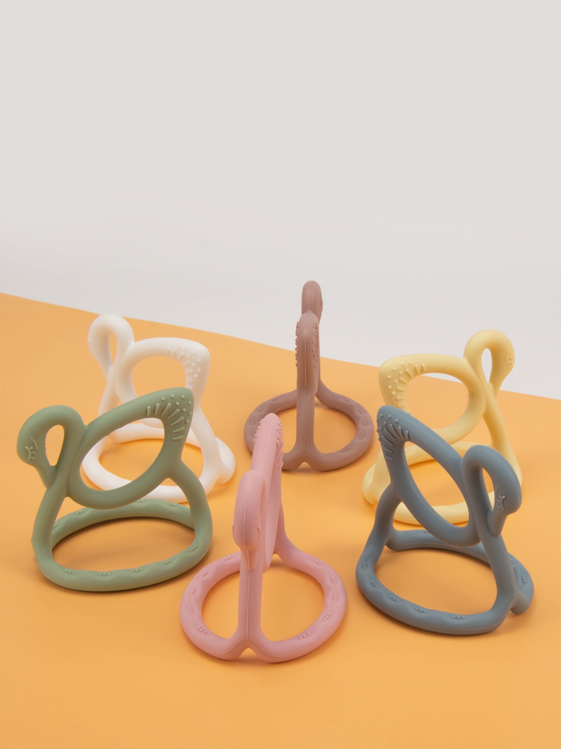 Assorted pastel swan teethers with ridged grips and loop handles