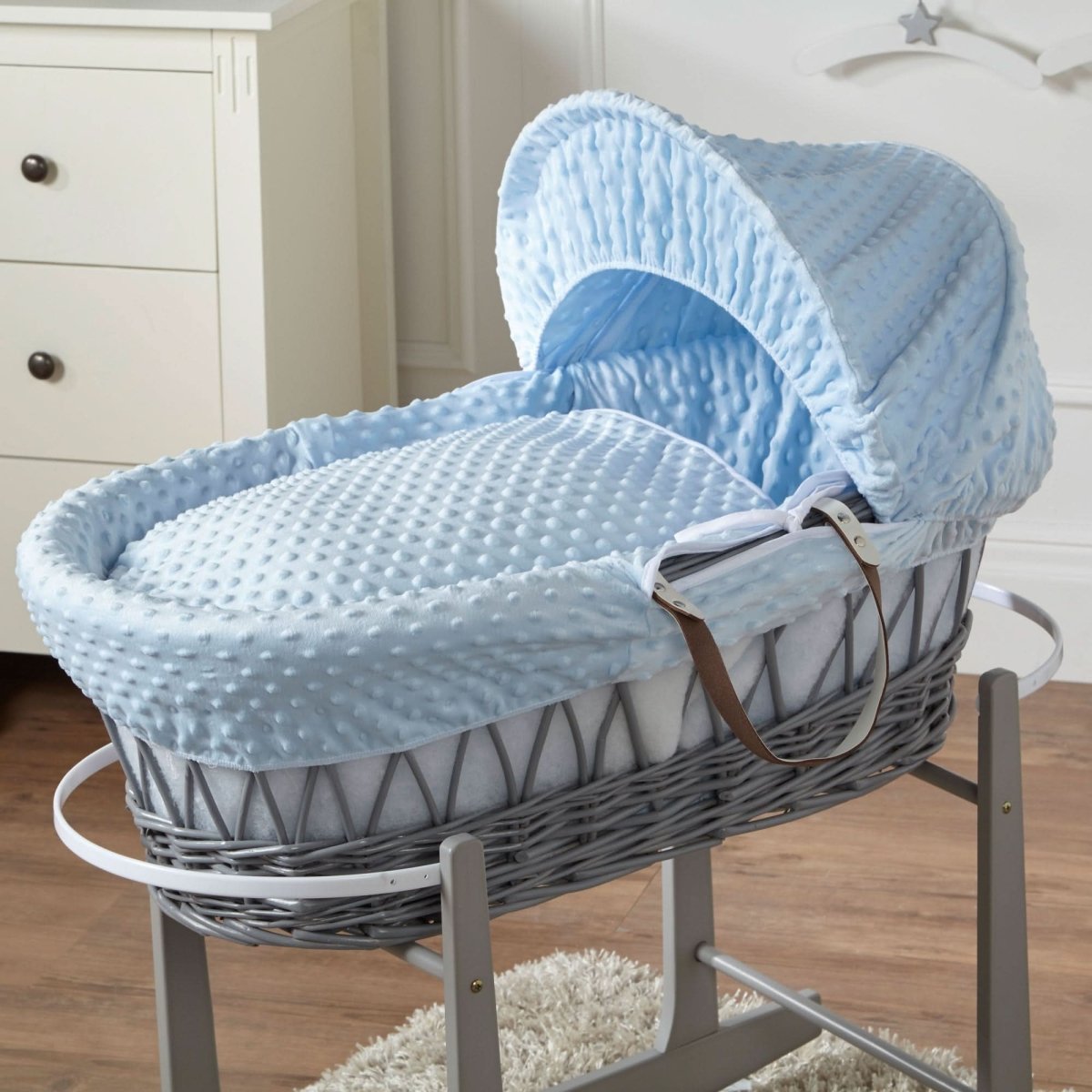 Close view of blue wicker Moses basket on stand with padded mattress and hood