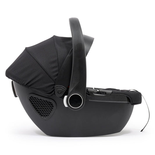 Black infant car seat with carry handle and integrated base, side view